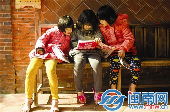 留守兒童收到捐贈的書籍迫不及待地看起來